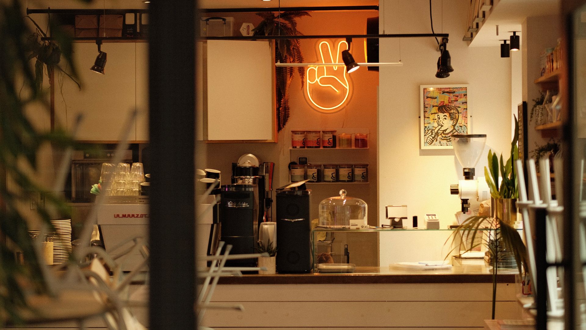 A cafe counter with an espresso machine under warm lights