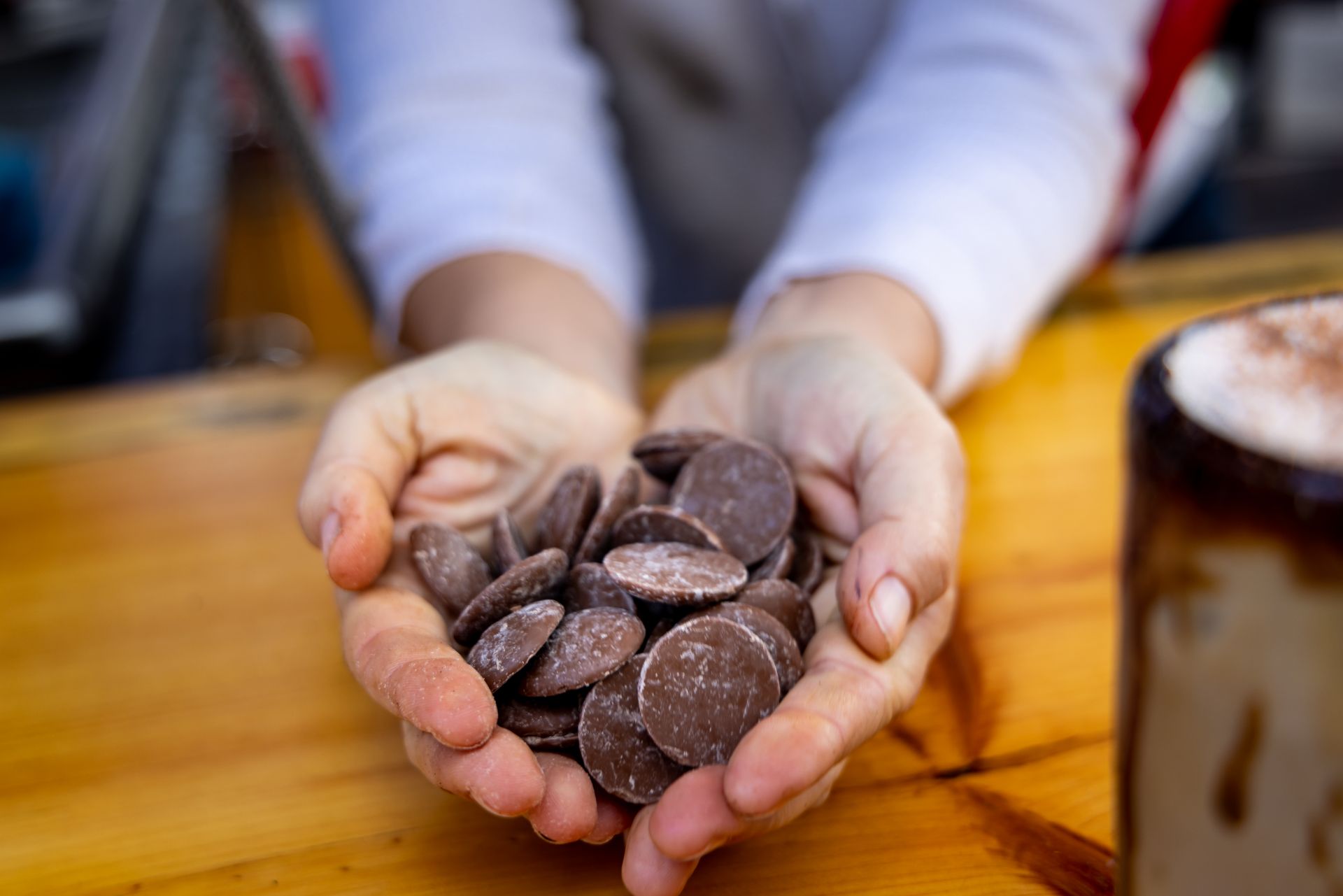 Cupped hands holding dark chocolate pieces